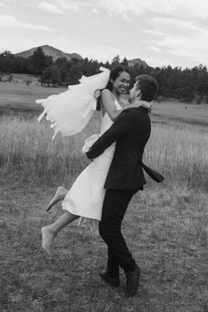 bride & groom twirling in the meadow