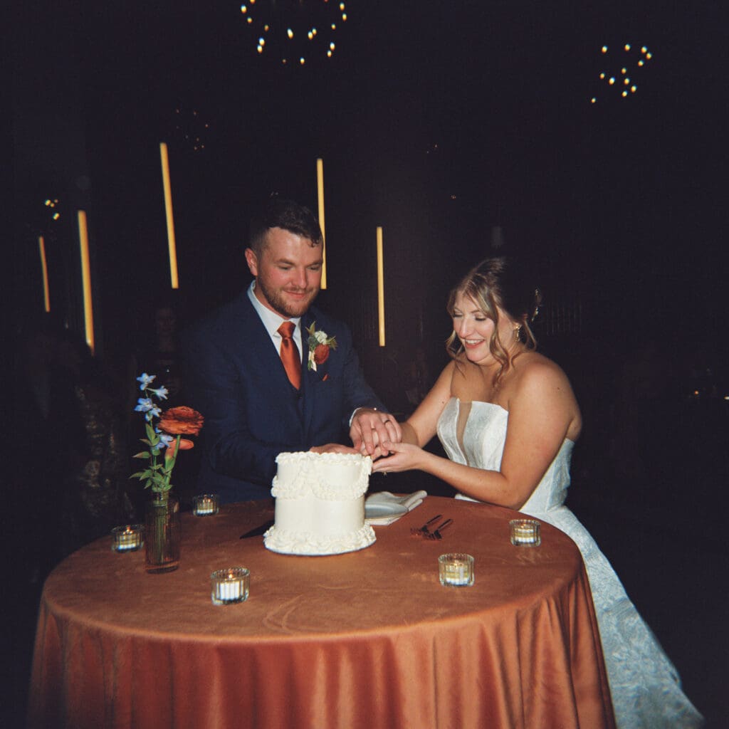 A bride and groom happily cut their wedding cake