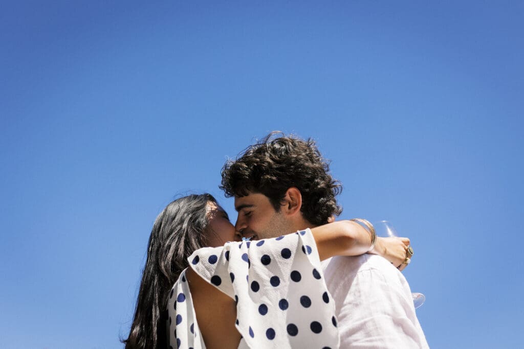 Couples pictured holding each other with the blue sky in the background